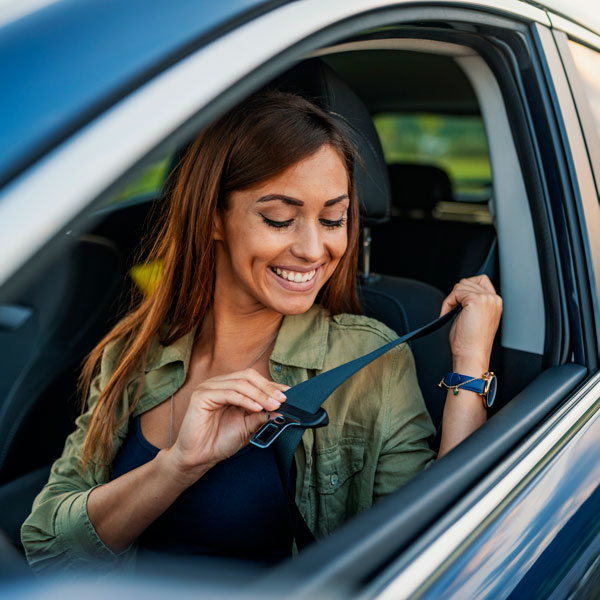 A woman buckling her seatbelt happily in the Greater Phoenix area