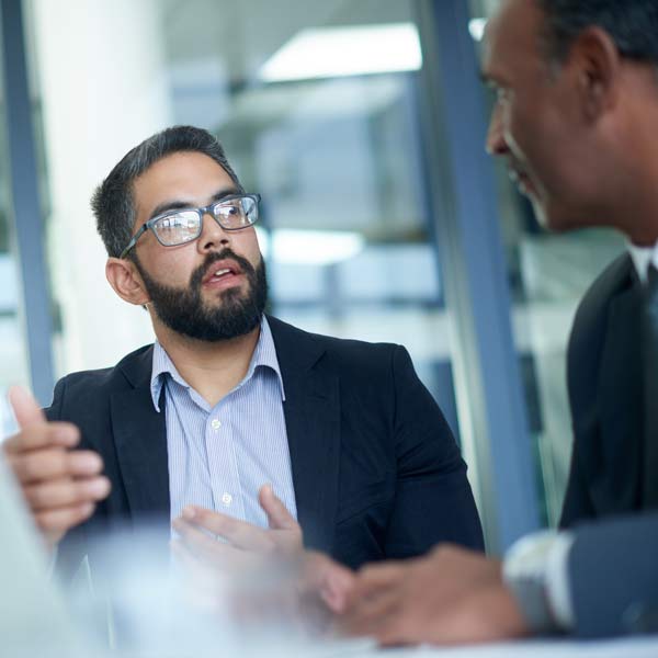 Two men in business attire engaged in a conversation in Phoenix, AZ