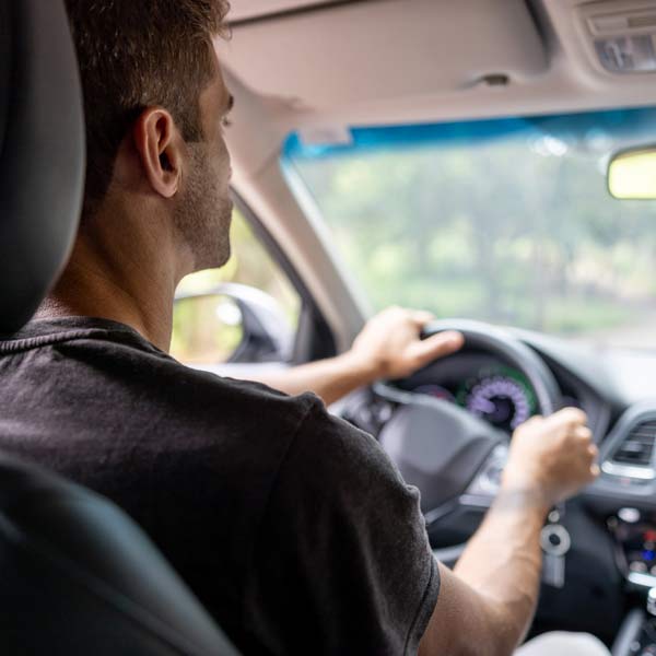 A man is focused on driving, hands firmly on the steering wheel in Phoenix, AZ